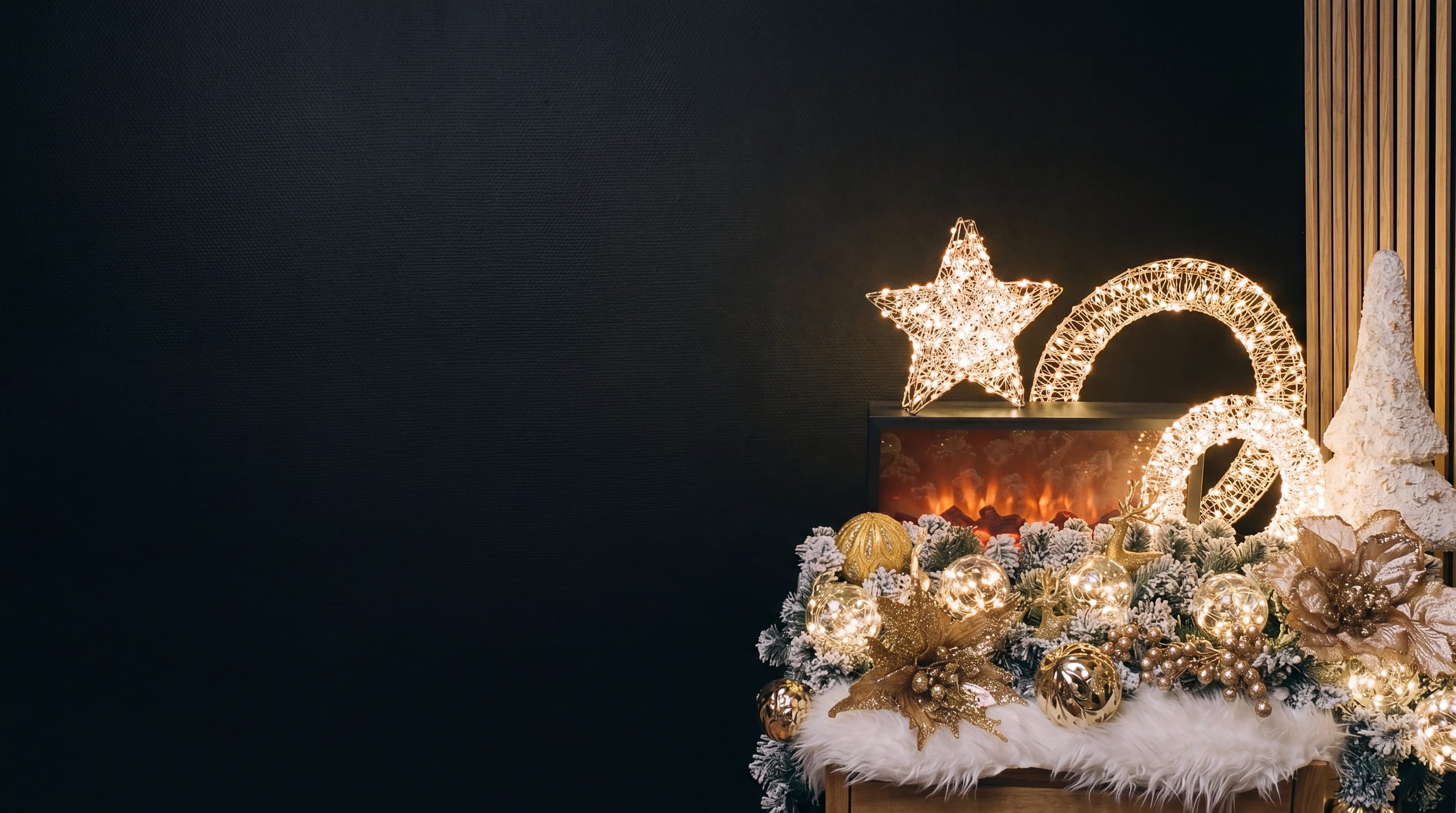 A mantelpiece in one of our stores, lit at dusk, with an LED star and a snow-dusted garland