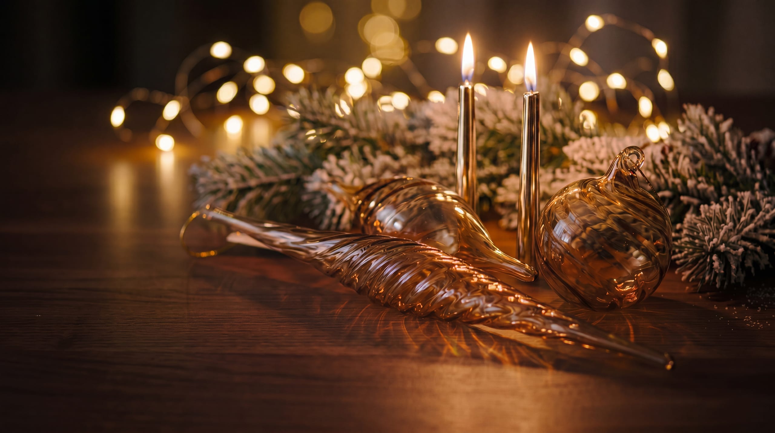 Lichtdurchlässiger Christbaumschmuck aus Glas und Kerzen im warmen Halbdunkel